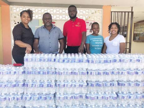 From left: Christine Lumsden; Stellavit Ingram, Central High principal; Lucien McIntosh; and past students Mickalia Huie and Shane Reid making the donation of bottled water as part of relief supplies for volcano-ravaged St Vincent and the Grenadines. 