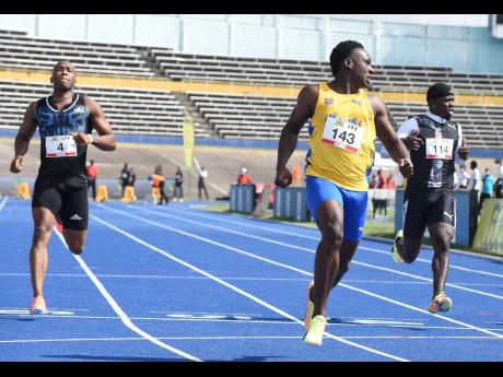 Sachin Dennis (centre) wins his heat in the men’s 100m ahead of Kenroy Anderson (left) and Javoy Tucker (right) during the JOA/JAAA Olympic Destiny  Meet at the National Stadium yesterday. Dennis clocked a personal best 10.15 seconds to finish as the fas