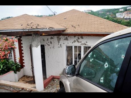 
The bullet-riddled house and vehicle at the Kirkland Heights home of Keith Clarke after the May 2010 operation in which he was killed by members of the security forces.