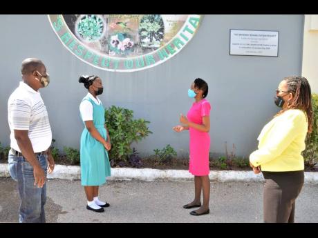 Grade seven student at Clarendon based Denbigh High School, Thian Nangle (second left), listens to her teacher, Jassett Blake (second right). Observing (from left) are: Thian's father, Errol Nangle, and Vice Principal of the school, Dianne Gordon-Denton.