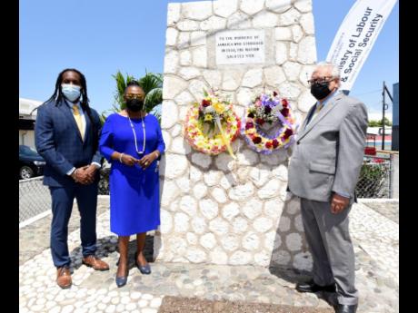 Minister of Labour and Social Security Karl Samuda (right) stands in front of the Aggie Bernard Monument in downtown Kingston on Tuesday, May 11 after laying wreaths in remembrance of the Jamaican workers who struggled in 1938. Also present are Minister of