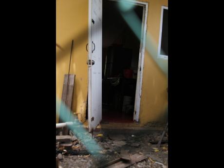 A broken door bears witness to a family dispute which turned deadly in Lionel Town, Clarendon, yesterday. Alrick Williams, who reportedly attacked his brother, was shot dead.