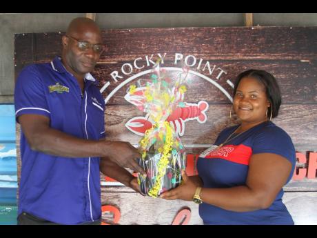 David Dixon, trade development officer, Rum Bar, the main sponsor of ‘Pasta Wednesdays’ presents a gift to Tanoy Dawkins at White Sands Beach Seafood Restaurant in Rocky Point, Clarendon.