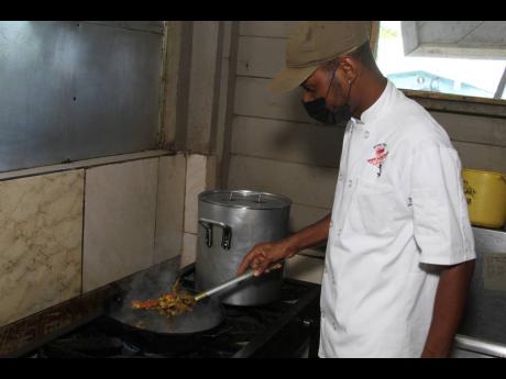  White Sands Beach Seafood Restaurant’s Chef Yakini Scott prepares a special dish of buttered crab. 