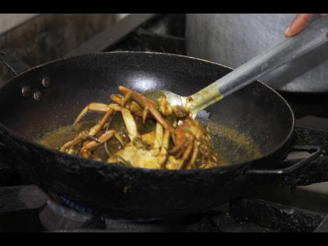 Chef Yakini Scott stirs the buttered crabs.