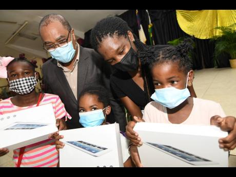 The Rev Dr Stevenson Samuels (left, background) and Jody-Ann Bennett, youth director of Waltham Park New Testament Church of God, interact with (from left) Priscilla Johnson, Israel Sculley, and Deborah Stewart after they were presented with tablets. The c