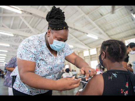 Jescinth Williams receives her COVID-19 jab from registered nurse Yanique Williams at the Mona Ageing and Wellness Centre during the vaccination blitz on Sunday, April 11.  