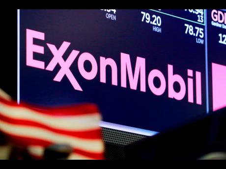 The logo for ExxonMobil appears above a trading post on the floor of the New York Stock Exchange on April 23, 2018.