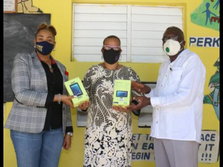 From left: Natalie Smellie-Sinclair, operations manager, National Pen Jamaica; Lorna Crooks, principal, Bogue HIll Primary and Infant School; and Bishop Conrad Pitkin, custos of St James, with some of the tablets donated to the school.