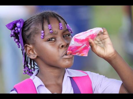 In this September 2011 file photo, a student drinks bag juice. With the closure of schools in 2020, due to the COVID-19 pandemic, bag juice producers have lost one of their most lucrative market channels and have turned to community shops to fill the gap.