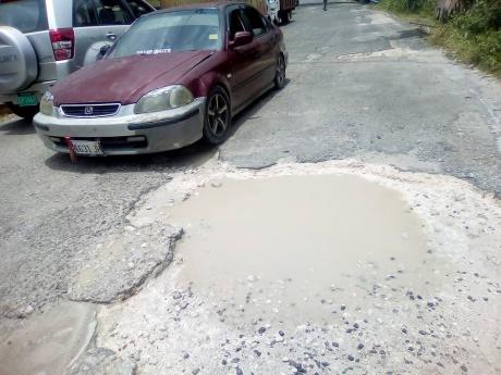 Motorists squeeze past each other on the Guy’s Hill main road that is pockmarked with potholes. One commuter said that he is so fearful that he wouldn’t trust riding a donkey on the thoroughfare. Repairs are due to commence in July, a counciller has sa