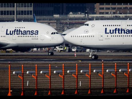 In this February 14, 2019 file photo, an Airbus A380, left, and a Boeing 747, both from Lufthansa airline, pass each other at the airport in Frankfurt, Germany.