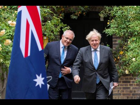 Prime Minister of Australia Scott Morrison, left, walks with Prime Minister of the United Kingdom Boris Johnson after their meeting, in the garden of 10 Downing Street, in London, Tuesday June 15, 2021.