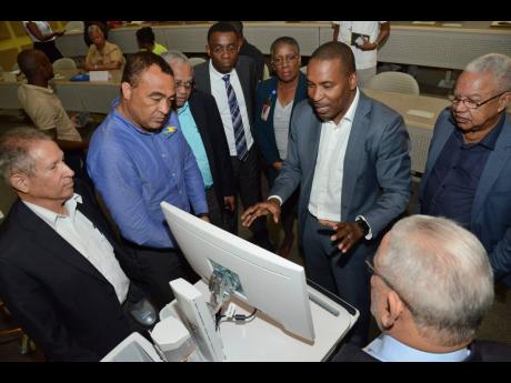 
Dr Carl Bruce (third right), medical chief of staff af the University Hospital of the West Indies, shows the hospital’s new information management system to health and IT specialists, (from left) Mark Thwaites, Dr Christopher Tufton, Professor Archibald