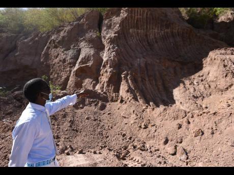 Kirk Patterson points to a mountain of silt build-up which he blames on mining activity.