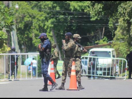 Police and soldiers man a security checkpoint yesterday at the entrance to the Norwood community in St James, where a zone of special operations is was declared on Sunday.
