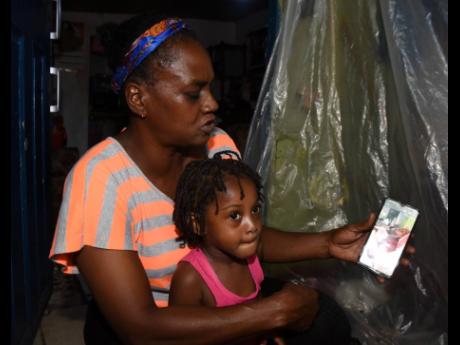 Lorraine Mendez holds her three-year-old granddaughter Chloe Saunders as they speak to Mendez’s daughter, 30-year-old Trishauna Blair, who survived a February 17 motor vehicle crash on South Camp Road that claimed the life of one person. Blair has been h