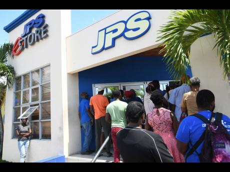 
Customers lined up awaiting service at the JPS Ruthven Raod branch in Kingston on March 23, 2020, days after the coronvirus pandemic was detected in Jamaica and social distancing protocols began taking effect.