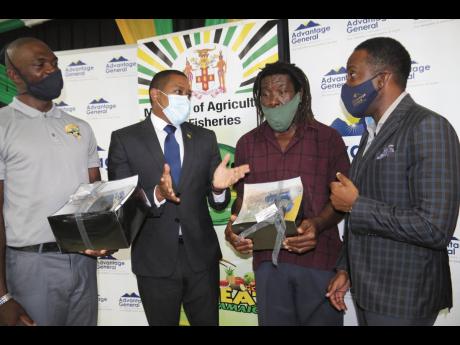 Minister of Agriculture and Fisheries Floyd Green (second left) converses with (from left) Jhananey Nicholson, coffee farmer; Junior McDonald, fisher; and Mark Thompson, president and CEO of Advantage General Insurance Company, at the launch of an insuranc