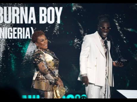 Nigeria's Burna Boy (right), accepts the Best International Act award as his mother Bose Ogulu looks on.