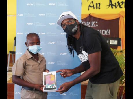 Wyenn Honeyghan, a Bethlehem Primary & Infant School student, accepts his Samsung tablet from Papa Michigan.