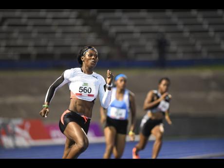 Shericka Jackson (left) sprints to victory in the women’s 200m semi-finals at the National Senior Championships at The National Stadium on Saturday, June 26, 2021.