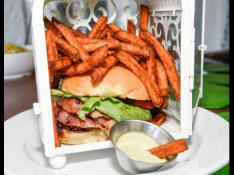 Indulge in the delights of the melted hearts burger —  local freshly made beef patty topped with pepper Jack cheese, bacon, lettuce, caramelised onions and tomatoes, and served with sweet potato fries.