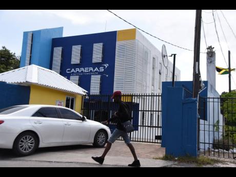 A pedestrian passes the Ripon Road, New Kingston, headquarters of Carreras on Wednesday. The cigarette distributor warns that draft tobacco legislation could imperil the gifting of scores of scholarships it issues annually.