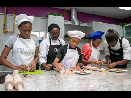Students participate in a summer camp cooking activity inside the Nestlé Corporate Kitchen. The students are being helped by the YOCUTA chefs (young culinary talents) in preparing a quick and easy meal of their choice to encourage healthy eating habits.