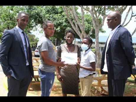 Avatar Muschette, grade-seven student of Clarendon College, Chapelton, accepts a tablet computer from Icylyn Green Whitfield of Pencils4Kids.  Looking on (from left) are Randy Griffiths, founder/president Pencils 4 Kids; Charmaine Warburton, Avatar’s mot
