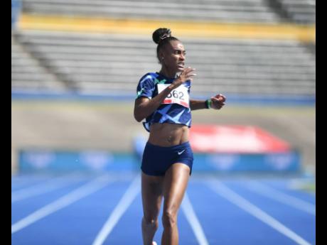 Stephenie-Ann McPherson looks to the clock as she crosses the line in the women’s 400m final at the National Senior Championships at the National Stadium on Sunday, June 27.