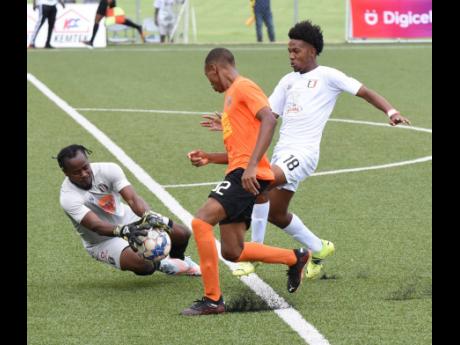 Tivoli Gardens’ Odean Pennycooke (centre) blocks off the onrushing Shadane Lopez (right) of Arnett Gardens, so his goalkeeper Kewong Watkins can grab the ball during their Jamaica Premier League match at the UWI/JFF/Captain Horace Burrell Centre of Excel