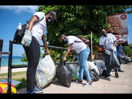 Volunteers bag plastics and other garbage cleared from the Old Hospital Park Beach in Montego Bay on Saturday. The activity was a collaboration between the Jamaica Environment Trust and the Coca-Cola Foundation. 