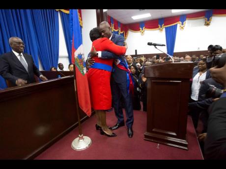 In this February 7, 2017 photo, Haitian President Jovenel Moise hugs his wife Martine after being sworn into Parliament in Port-au-Prince, Haiti. 