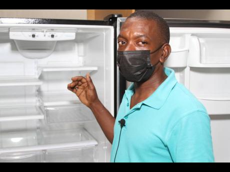 Electrician Hopeton Henry speaks of the importance of adjusting the temperature of a refrigerator during the summer.