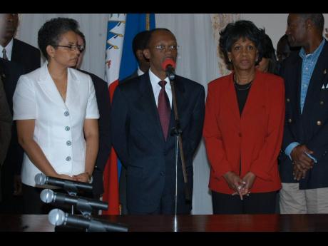 
Jean Bertrand Aristide and his wife Mildred (left) address a press conference on February 21, 2004 at Haiti’s presidential palace eight days before he was ousted as president. On the right is US Congresswoman Maxine Waters.