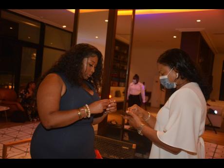 Tareka Coney (left) exchanges business cards with Odette Dyer, regional manager, Jamaica Tourist Board.