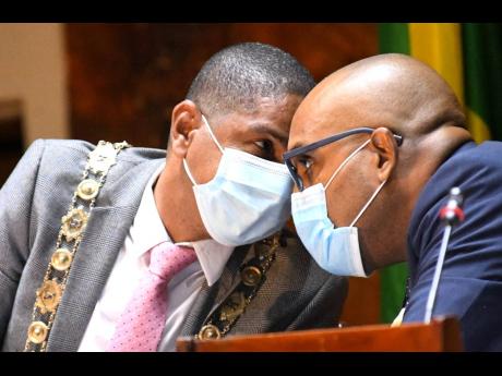Kingston Mayor Delroy Williams (left) has a tete-a-tete with Robert Hill, town clerk, at Tuesday’s meeting of the Kingston and St Andrew Municipal Corporation at the Jamaica Conference Centre.
