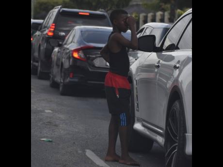 A street boy begs alms along West Kings House Road in St Andrew on Wednesday. Research by the Child Protection and Family Services Agency highlighted that children who work and live on the streets have social-protection needs.