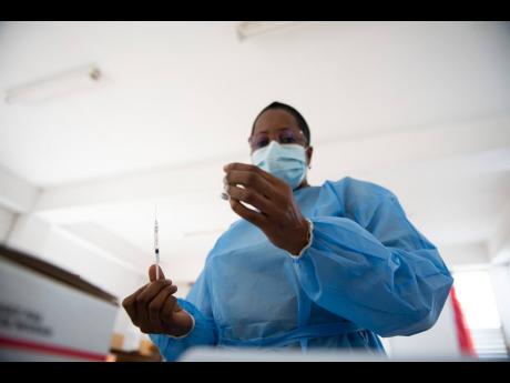 Public Health Nurse Kathy-Ann Bryan prepares a dose of Astrazeneca vaccine.