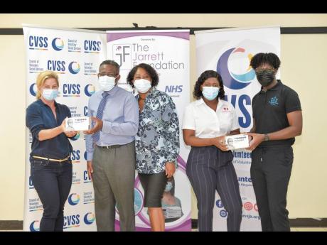 Dr Pearl Jarrett (centre), chief executive director of the Jarrett Foundation and her husband, Earl Jarrett (second left), present masks to Nancy Pinchas (left), executive director of the CVSS; Jodiann Spence (second right), case manager at Eve for Life; a
