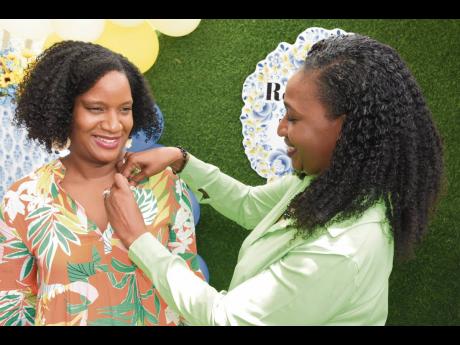 Janelle Pantry Coke (left), founder and creative director of Spaces, is pinned by president of the Rotary Club of Trafalgar New Heights 2021-2022, Dr Suzanne McDonald Fowles, as she is installed as the club’s new director of administration. Pantry Coke s