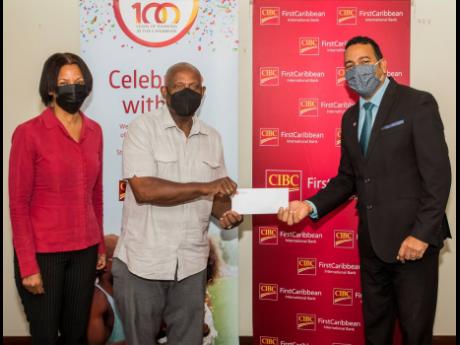 Nigel Holness (right), managing director, CIBC FirstCaribbean, presents a cheque to Lorenzo Ellis and Monica Walker for the Haile Selassie High School Incentive Programme.  The initiative targets grades seven to nine to encourage school attendance and assi