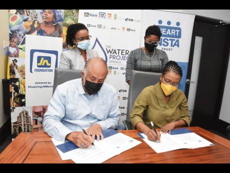 Parris Lyew-Ayee (left), chairman, JN Foundation and Novelette Denton-Prince (right), acting managing director, HEART/NSTA Trust sign a Memorandum of Understanding for academic programme enrichment, where the institution will offer courses in rainwater har