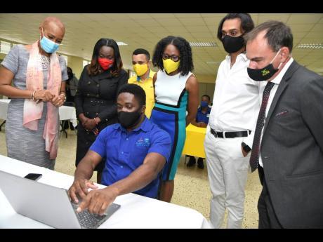 Coding student Richard Wilson demonstrates how to code for (from left) Fayval Williams, Minister of Education, Youth and Information; Kay-Marie Forbes-Robotham, Director, Strategic Partnerships Research and Innovation of HEART Trust/NTA; Andrew Pairman, CE