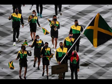Team Jamaica, led by flag-bearers Ricardo 'Big 12' Brown (front second right), and Shelly-Ann Fraser-Pryce (front right), march into the Olympic Stadium during the opening ceremony of the Olympic Games in Tokyo, Japan on Friday morning.