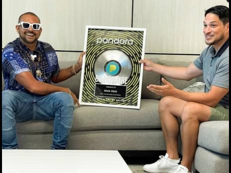 Reggae-dancehall artiste Sean Paul (left) receives his Pandora Billionaires’ Club plaque from Diego Herrera, Pandora’s head of Caribbean programming.
