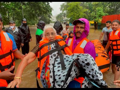 A National Disaster Response Force personnel rescues an elderly woman stranded in floodwaters in Kolhapur, in the western Indian state of Maharashtra yesterday.