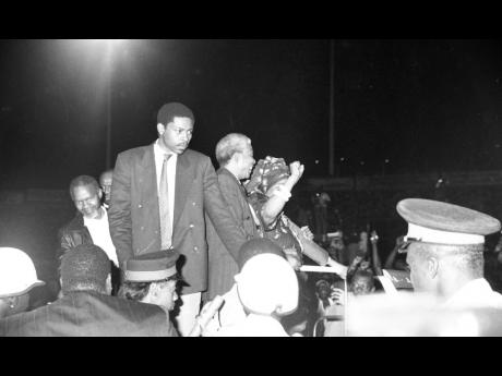 Jamaicans from all over lined up to see the Mandelas. In this photo, Winnie Mandela (right), raises her fist to the crowd as she stands beside husband, Nelson Mandela. 