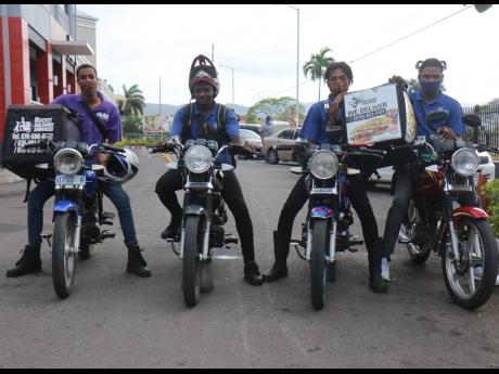Motorcycle couriers (from left) Romario McCalla, Rocket Delivery Services; Nicholas Linton, supervisor Damian Smith, and Shamar Fray, all of Errand Express, on duty, via online portal ENDS, at a KFC-Pizza Hut site in Montego Bay during lockdown. 